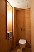 Toilette mit Holzverkleidung und Einbauschrank
