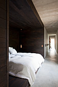Bett in einer mit dunklem Holz verkleideten Nische im langen Flur