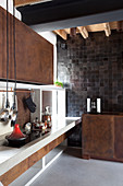 Küche im Designerstil mit rostigen Metallfronten und Betonboden