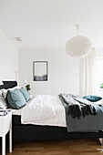 Double bed in bedroom with white walls