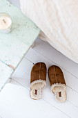 Sheepskin and leather slippers next to bed