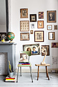 Nostalgische Bilder in Sepia an der Wand über altem Stuhl und Hocker