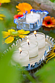Fringed floating candle holders hand-made from sardine cans and flowers floating in sandstone trough