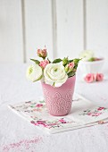 Ranunculus and roses in pink vase