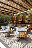 Wooden chairs with cushions on roofed terrace