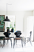White dining table and black chairs on white wooden floor
