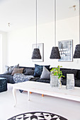 Pendant lamps above white coffee table and grey sofa with scatter cushions