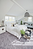 Bright bedroom in gray and white under the roof