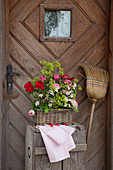 Bouquet of roses and lady's mantle in basket in front of front door
