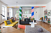 Colourful partition with wide stripes and lounge area in open-plan interior