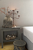 Rustic accessories in shades of grey on small table next to bed