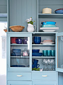 Blue lacquered display cabinet with dishes
