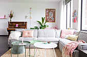 Pale grey sofa, piano and pastel accessories in living room