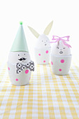 Whimsically decorated eggs in eggcups