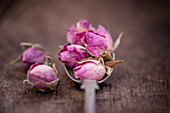 Dry rose buds on a spoon
