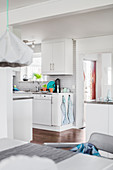 Blick vom Esstisch in die helle, weiße Küche