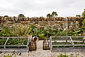 Two cold frames with strawberries in front of a rustic stone wall
