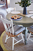 Round dining table with wooden chairs on carpet