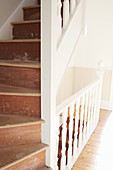 Old wooden staircase with worn treads and white balustrade
