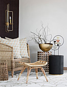 Wicker armchair and small side tables in natural shades in seating area
