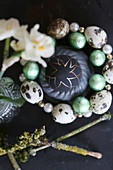 Easter egg painted black and gold in circlet of quail eggs