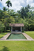Pavilion with a tiled roof by the pool in the garden
