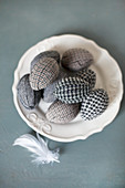 Easter eggs wrapped in fabric on plate