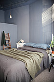 Double bed in bedroom with grey wall