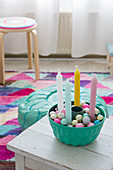 Colourful candles and baubles in turquoise bundt cake tin