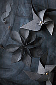 Windmills and flower made from black paper on black fabric