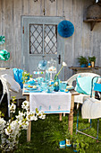 Table set in shades of blue with hand-made decorations in spring garden