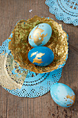 Easter eggs and handmade papier-mâché bowl decorated in blue and gold