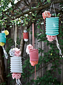 Mit DIY-Papierblüten verzierte Lampions im Garten