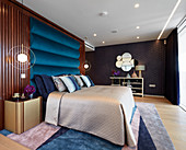 Glamorous bedroom in blue and metallic shades with various surface structures