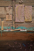Hand-made linocut printing blocks and carving tools on wooden surface