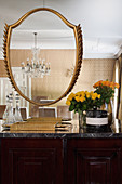 Gold frames on mirrored wall in glamorous dining room