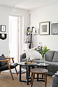 Coffee table, leather chair and grey sofa in living room with white walls
