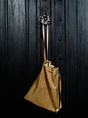 Pale leather bag hung from furniture door knob