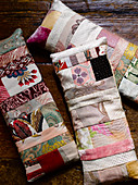 Three long patchwork cushions made from feminine fabrics