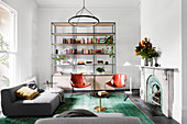 Gray upholstered sofa, leather chair in front of an open shelf and fireplace in the living room