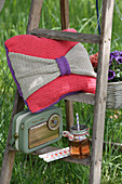 Crocheted cushion with bow and retro radio on ladder