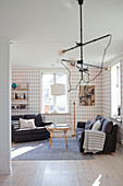 Industrial lamp in front of living room with diamond-patterned wallpaper
