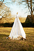 Cushions in hand-made teepee in autumnal garden