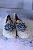 White, crocheted slippers with blue flowers