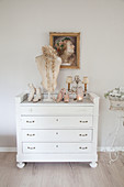 Vintage bust and old shoes on top of white chest of drawers