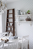 Ladder next to wall-mounted shelves in dining room with diamond-patterned wallpaper