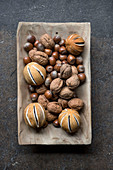 Dried orange pomanders and nuts in wooden dish
