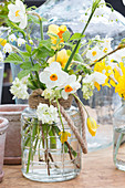 Bouquet of various types of narcissus in glass vase