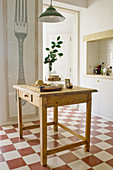 Old table with drawer on chequered tiled kitchen floor