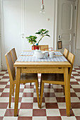 Dining table and chairs on chequered tiled floor